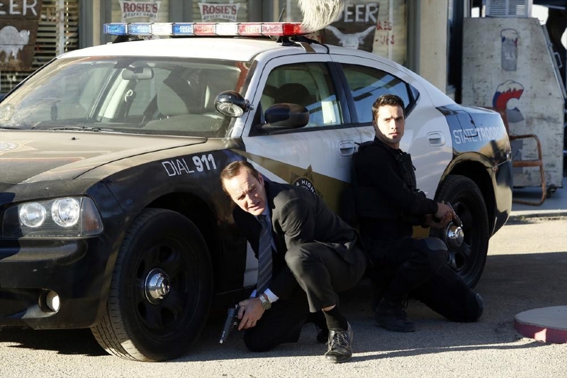 Coulson et Ward s'abritent derrière une voiture de police
