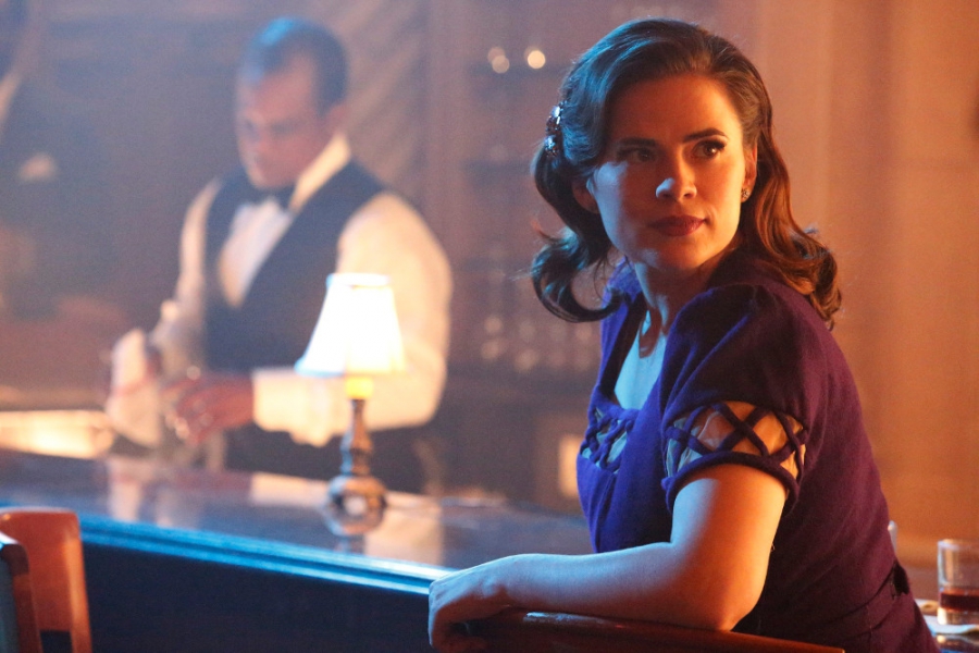 Peggy Carter (Hayley Atwell) assise au bar