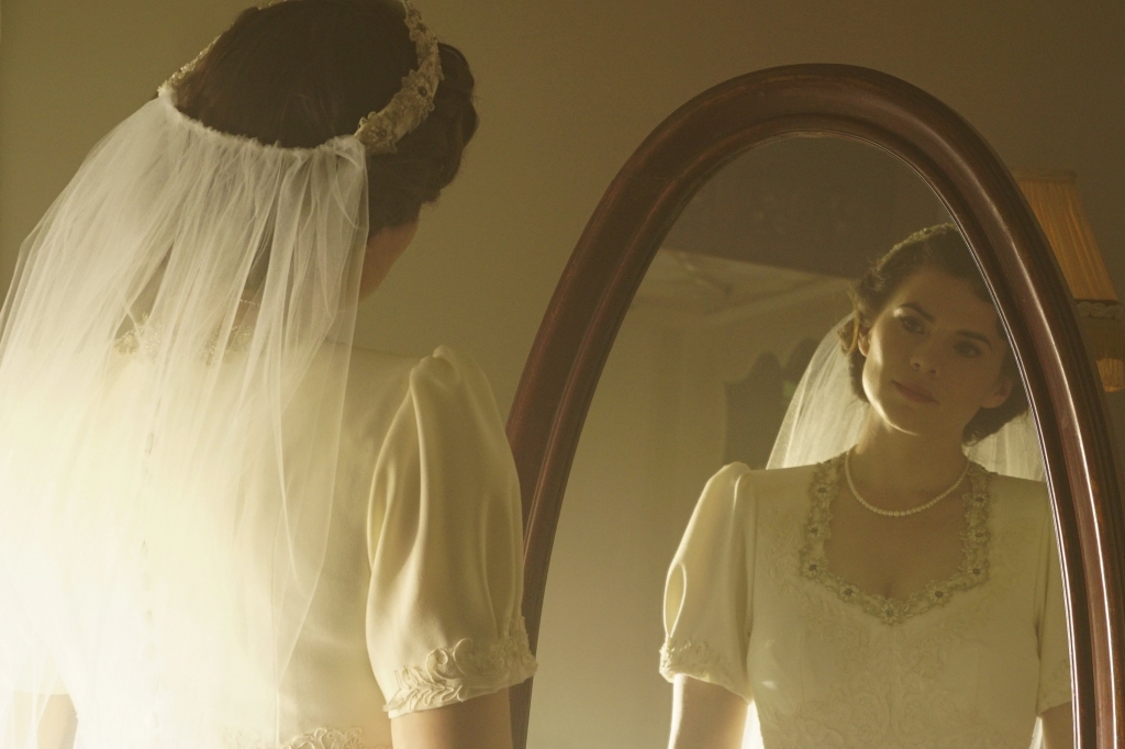 Peggy Carter (Hayley Atwell) se regarde dans le miroir en robe de mariée